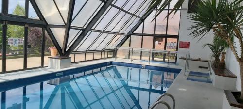an indoor swimming pool with a glass ceiling at Appartement Domaine des Yearlings DEAUVILLE in Deauville