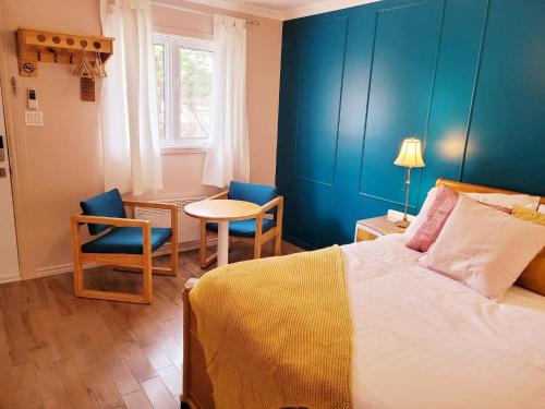 a bedroom with a bed and a table and chairs at Motel Abricafé in Stoneham