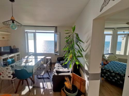 a living room with a table and a dining room at Appartement Cosy in Ault