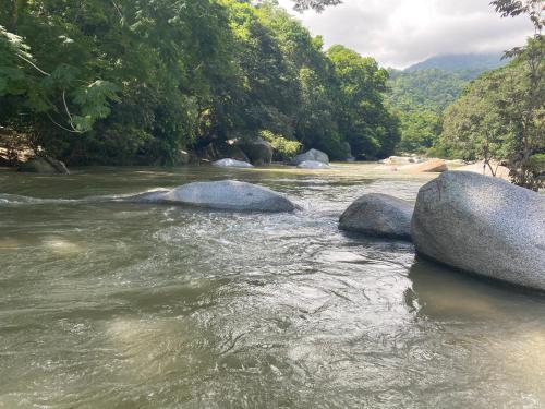 a river with two large rocks in the water at WAYANAY TAYRONA ECO HOSTEL in El Zaino