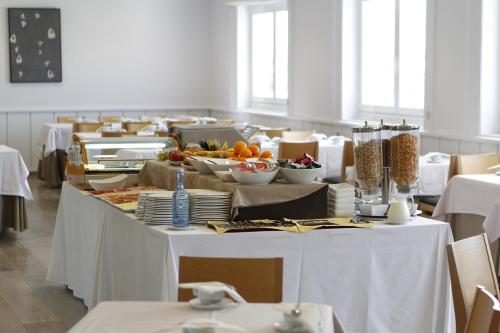 a long table with white tables with food on it at Hotel Mendez Nuñez in Lugo