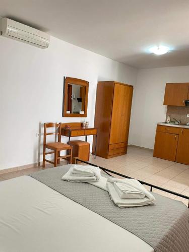 a bedroom with a bed and a table and a kitchen at Vythos in Adamas