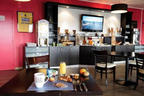 comedor con mesa y cocina con bar en Kyriad Evreux - Netreville, en Évreux