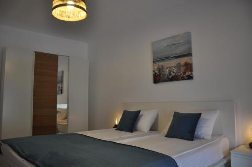 a bedroom with two beds and a mirror and a chandelier at Coral ONIX in Neptun