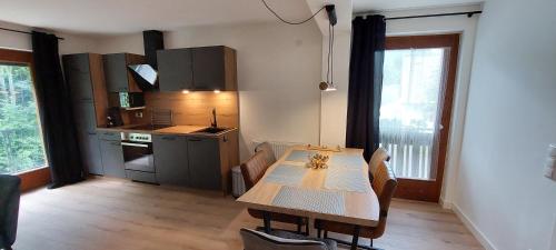 a kitchen with a wooden table and a kitchen with a counter at Gailtaler Apartments Alinkhof in Bach