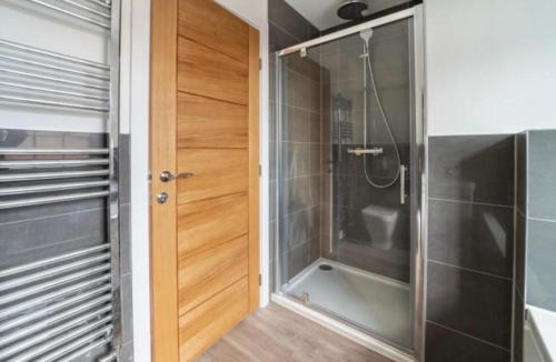 uma casa de banho com um chuveiro e uma porta de vidro em Stunning New Townhouse in the Heart of Warwick em Warwick