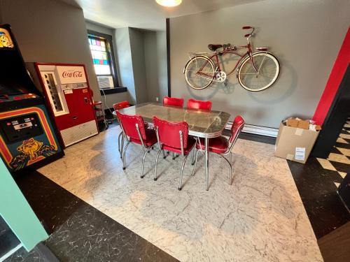 a table and chairs with a bike hanging on a wall at Cool, Retro Getaway in Heart of Downtown in Bellefonte
