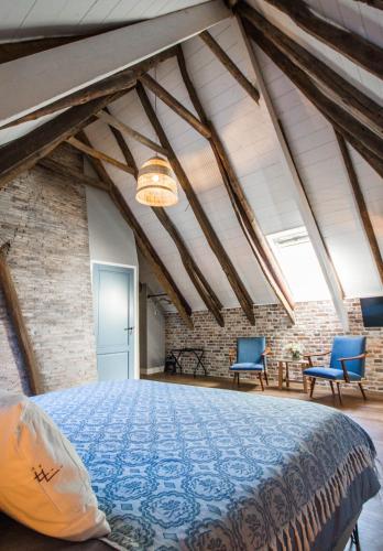 a bedroom with a large bed in a brick wall at Juffertje in het groen in Zwolle