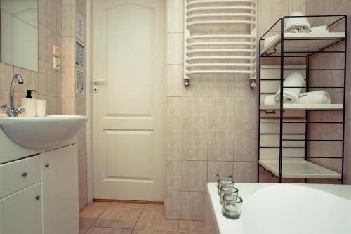 łazienka z umywalką i półką z ręcznikami w obiekcie Apartament Giencyno Koncina Zakopane w Zakopanem