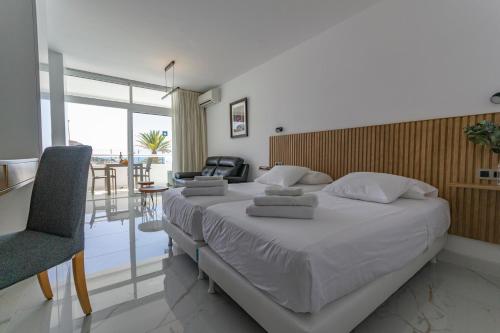a bedroom with a large bed and a chair at Apartamento Tobago - Puerto Rico in Puerto Rico de Gran Canaria