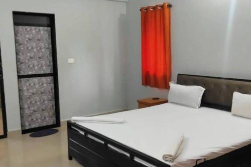 ein Schlafzimmer mit einem Bett und einem roten Vorhang in der Unterkunft Park Grand Boutique 3 Bedroom Bungalow in Marmagao