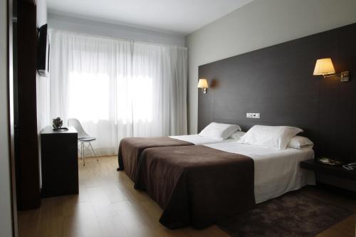 a hotel room with a large bed and a window at Hotel Mendez Nuñez in Lugo