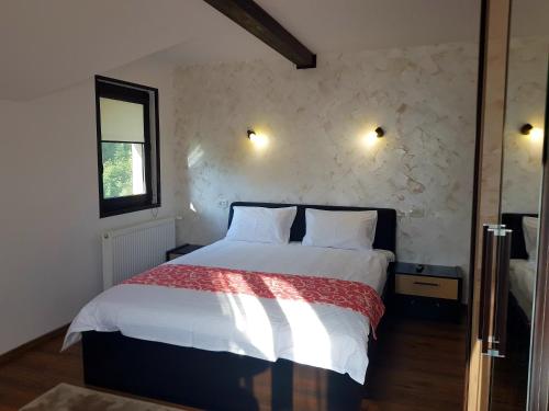 Schlafzimmer mit einem Bett mit weißer Bettwäsche und einem Fenster in der Unterkunft Cazare la munte Comarnic in Comarnic