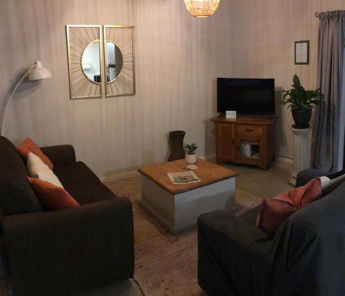 ein Wohnzimmer mit 2 Sofas und einem TV in der Unterkunft Cosy Country Stay B&B in Matamata