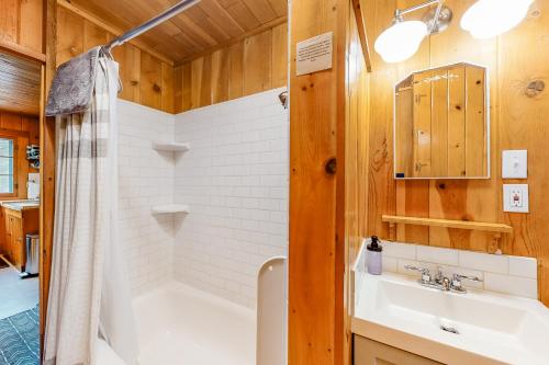 a bathroom with a tub and a sink and a shower at Knotty Pine Cabin in Joseph
