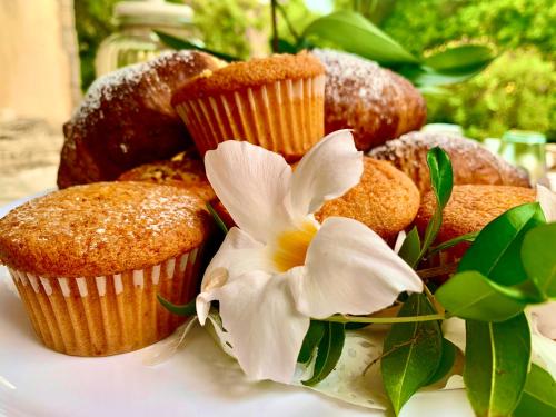a plate of muffins and donuts with a flower on it at Villa Franci in Santa Teresa Gallura