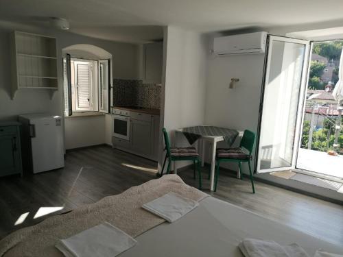 una camera con letto, tavolo e sedie di Apartments & Rooms Dinko a Valun