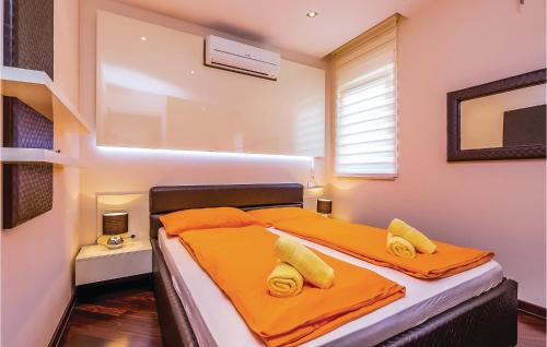 a bedroom with a bed with orange sheets and yellow pillows at Beautiful Apartment In Crikvenica With Wifi in Crikvenica