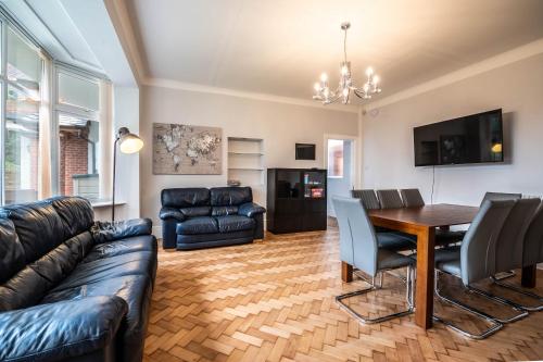 a living room with a couch and a dining room table at The Manor - Large Luxury home in Bournemouth - Sleeps 12+ in Bournemouth