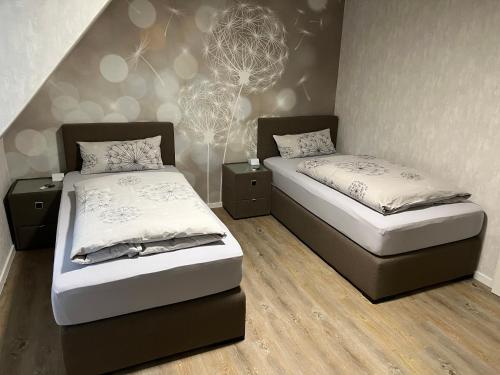 a bedroom with two beds and a wall at Peedy's luxuriöse 60m² Wohnung mit Balkonterrasse in Stade