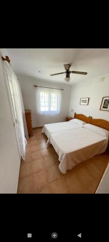 sypialnia z dużym białym łóżkiem i oknem w obiekcie Bonito apartamento con terrazas y aparcamiento. w Son Bou