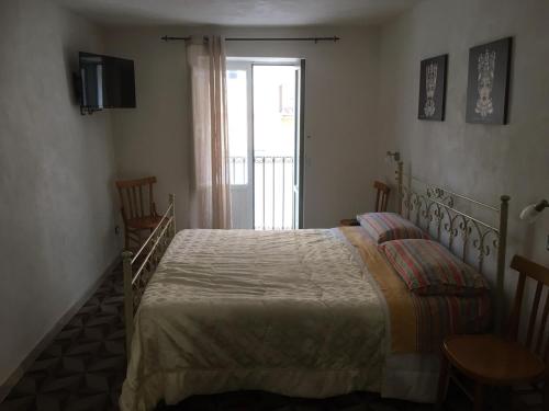 Un dormitorio con una cama y un televisor y una ventana. en Casa Movida, en Trapani