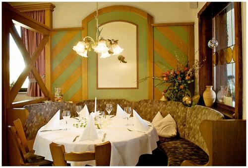 a dining room with a table and a couch at Hotel Bayerischer Hof in Lindenberg im Allgäu