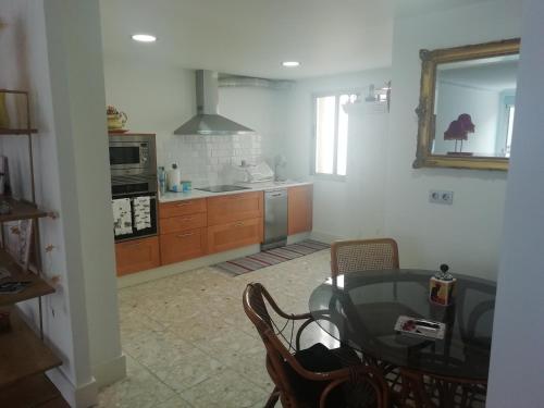 eine Küche mit einem Glastisch und einem Esszimmer in der Unterkunft Céntrico y amplio piso con plaza parking in Cangas