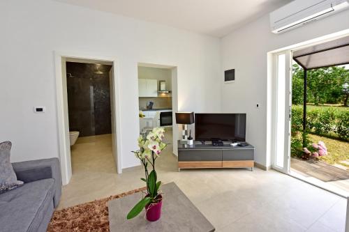 a living room with a vase with flowers in it at Apartman Melita in Poreč