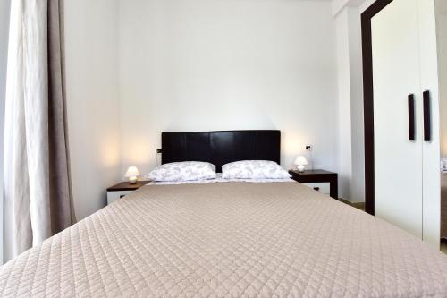 a bedroom with a large white bed with two night stands at Apartman Melita in Poreč