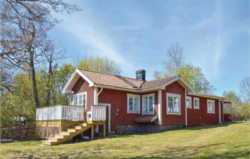 a red house with a deck in the yard at Lovely Home In Gräddö With Sauna in Gräddö