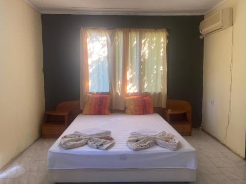 a bedroom with a bed with two pairs of shoes on it at Морска База Венера in Tsarevo