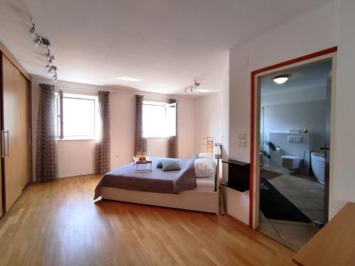 a bedroom with a bed and a bathroom with a mirror at Apartment Teleferica Rabac in Rabac