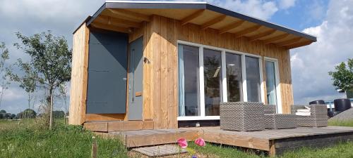 a tiny house sitting on top of a field at Tiny house het Polderhuisje in Streefkerk