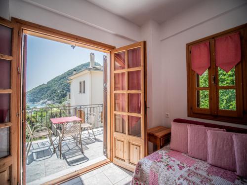 a bedroom with a door open to a balcony at Cherry House in Damouchari with a sea view - Delicious Houses in Damouchari