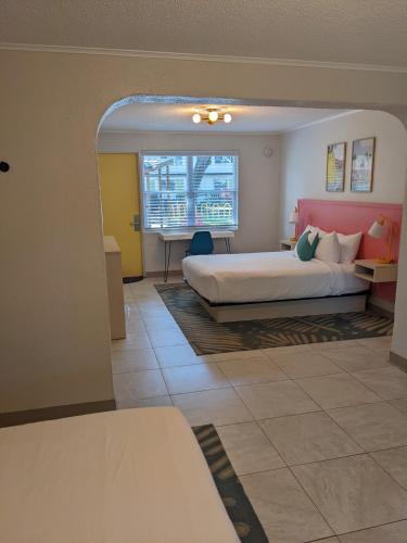 a hotel room with a bed and a window at Queen's Court Inn in Saint Simons Island