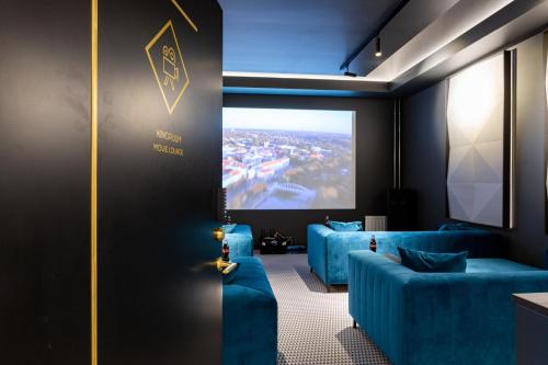a room with two blue couches and a projection screen at Golden Residence in Tartu Center by EasyRentals in Tartu