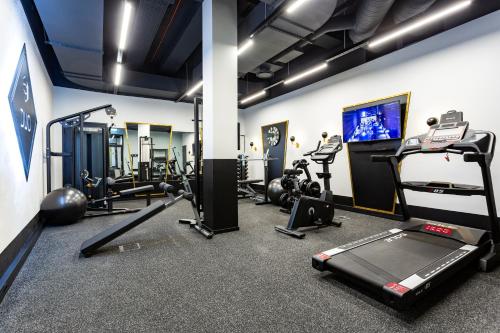 a gym with tread machines and a flat screen tv at Golden Residence in Tartu Center by EasyRentals in Tartu