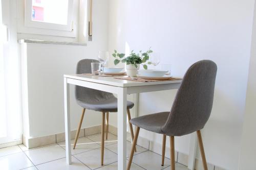 a dining room table with two chairs and a white table at Cozy apartment with Free Parking & close to Lake in Lugano