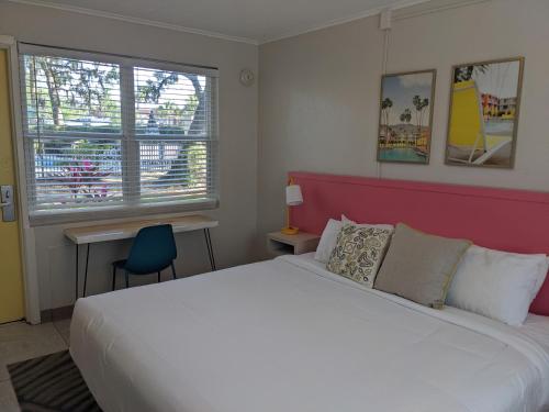 a bedroom with a large white bed and a blue chair at Queen's Court Inn in Saint Simons Island