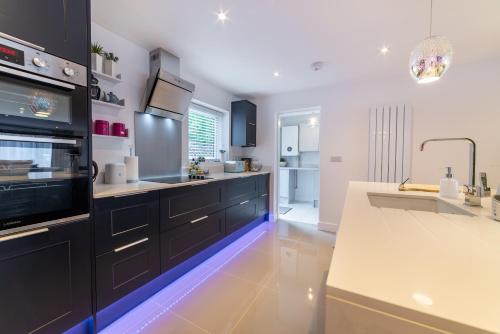 a kitchen with black cabinets and a white counter top at Llanberis Lodges in Llanberis