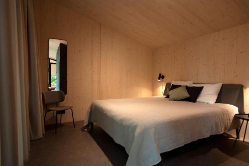 a bedroom with a bed and a chair and a window at Buitenplaats Petersburg in Arnhem