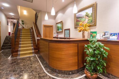 a lobby with a reception counter and stairs at Hotel Herradura in Santiago de Compostela