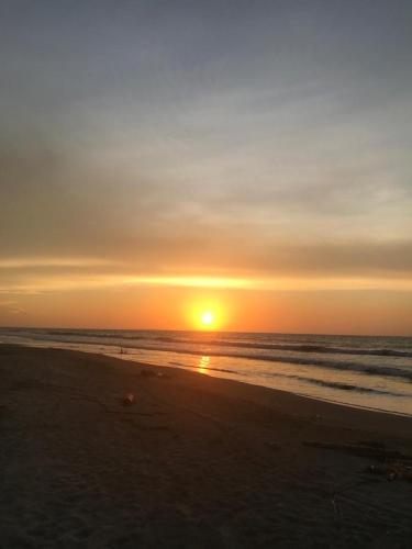 a sunset on a beach with the ocean at Cabaña La Blanquita in San Bernardo del Viento