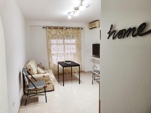 uma sala de estar com uma placa de casa na parede em Apartamento Puerto II em Mazagón