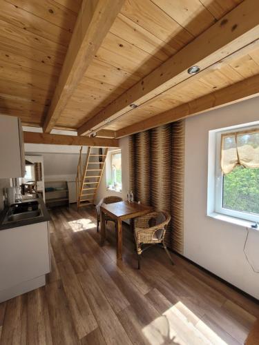 una cucina e una sala da pranzo con soffitto in legno di Rennsteigscheune a Steinbach am Wald