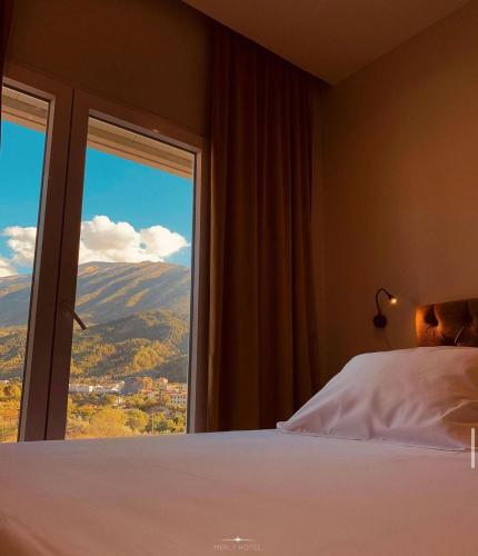 a bedroom with a bed and a window with a view at Merly Hotel in Përmet