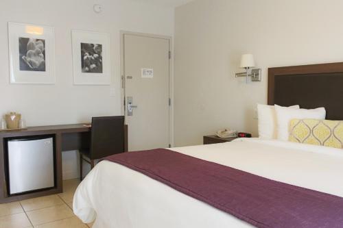 a hotel room with a large bed and a desk at Collins Hotel in Miami Beach