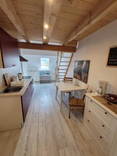 uma cozinha com pisos de madeira e um tecto de madeira em Rennsteigscheune em Steinbach am Wald