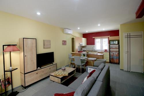 a living room with a couch and a tv and a kitchen at Seaside, relaxing family house with playground! Villa Lavrys 3 in Marathi